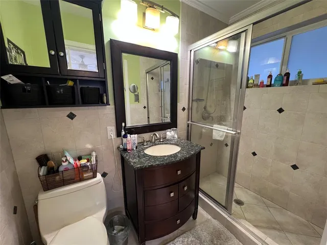 a bathroom with a granite countertop toilet sink and mirror
