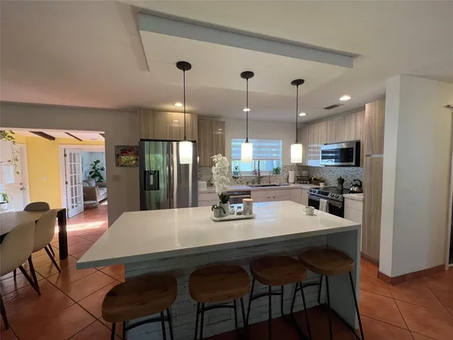 a kitchen with a dining table chairs and refrigerator