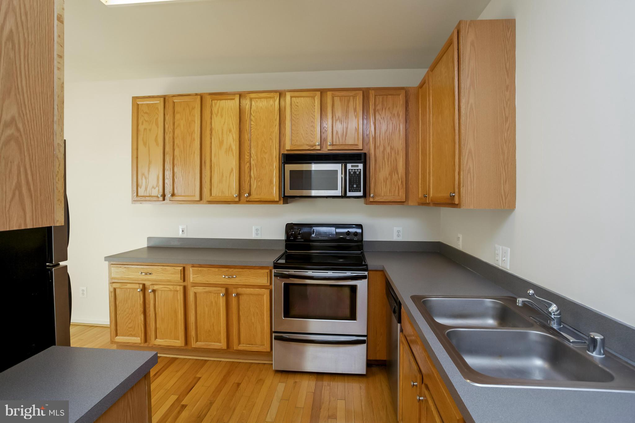 4130 Cutty Sark Road Baltimore, MD 21220 - Photo 12 of 24 a kitchen with a sink a microwave a stove and refrigerator