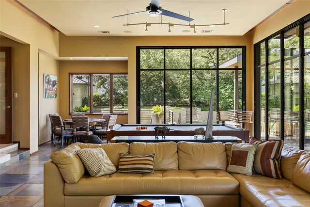 a living room with furniture a floor to ceiling window and floor to ceiling window