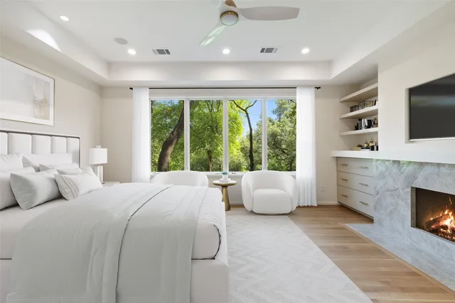 an empty room with windows a fireplace and a fireplace