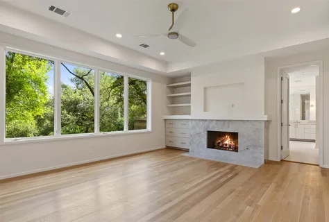 an empty room with windows and a fireplace