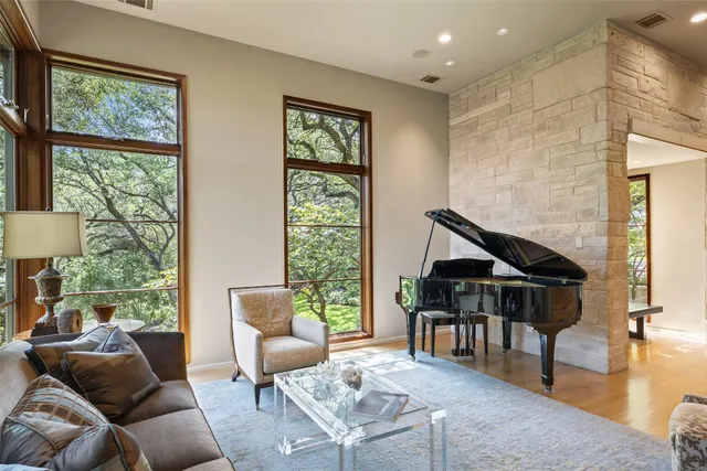 a living room with a fireplace and a floor to ceiling window