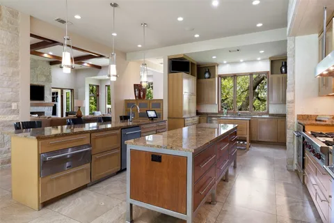a dining room with stainless steel appliances kitchen island granite countertop a table chairs and a view of living room