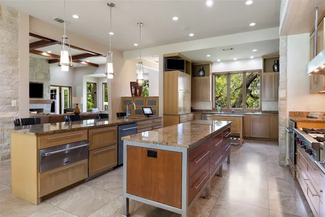 a dining room with stainless steel appliances kitchen island granite countertop a table chairs and a view of living room