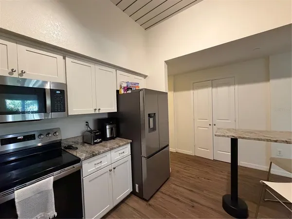 a kitchen with a refrigerator sink and cabinets