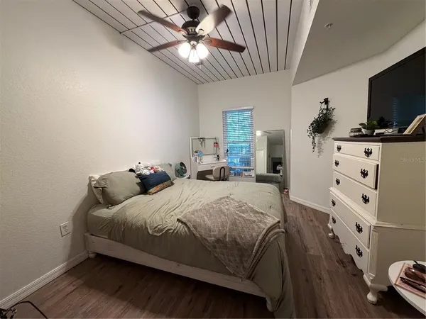 a bedroom with a bed and a flat tv screen on dresser