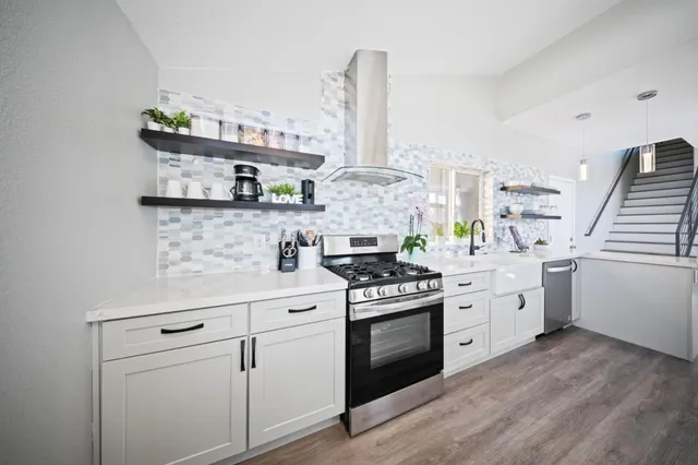 a kitchen with white cabinets appliances and sink