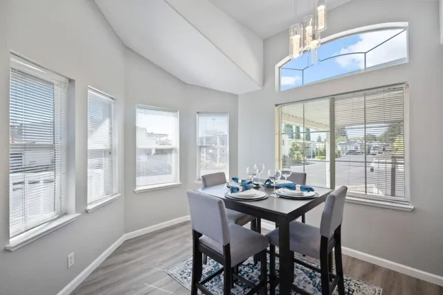 a dining room with furniture a chandelier and wooden floor