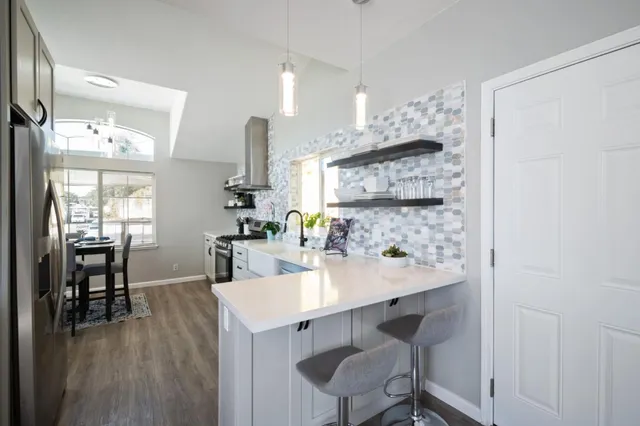 a kitchen with stainless steel appliances a sink cabinets and wooden floor