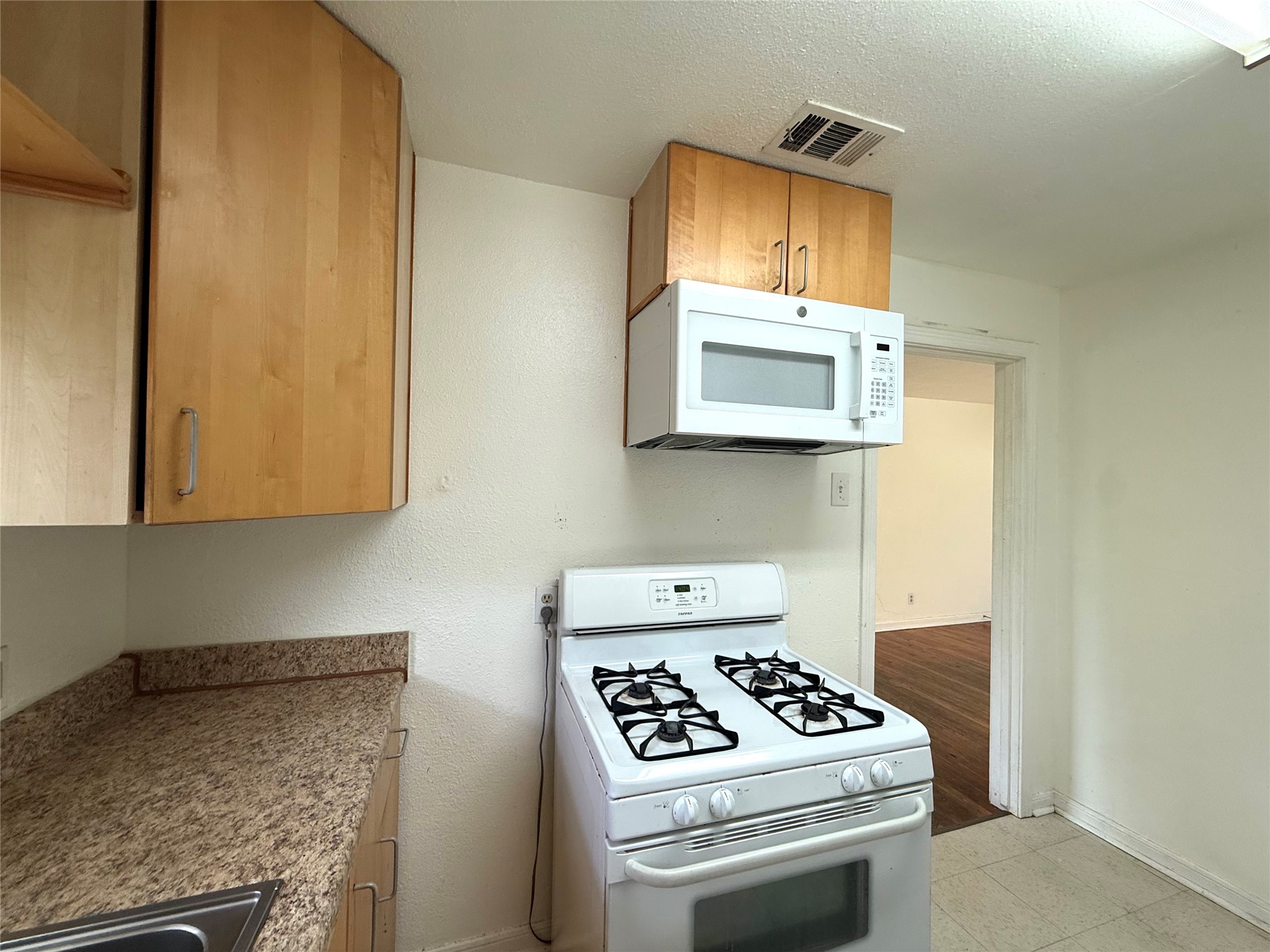 3305 Merrie Lynn Avenue Austin, TX 78722 - Photo 8 of 22 A compact culinary space features an over-the-range microwave and a gas range.
