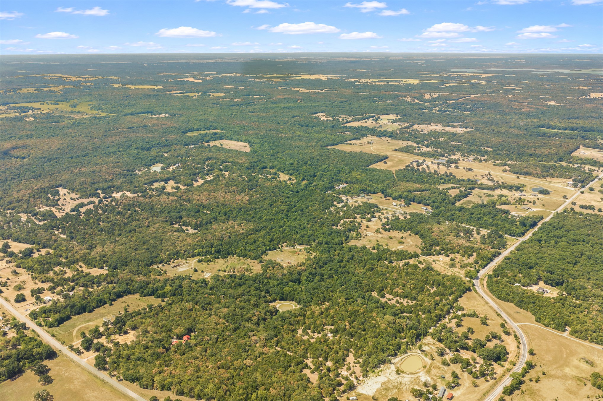 23922 Pickens Road Madill, OK 73446 - Photo 19 of 19 Expansive rural landscape featuring wooded areas, open fields, and winding roadways