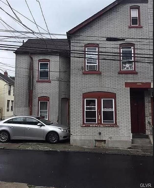a couple of cars parked in front of a house