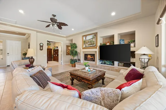 a living room with furniture ceiling fan and a flat screen tv
