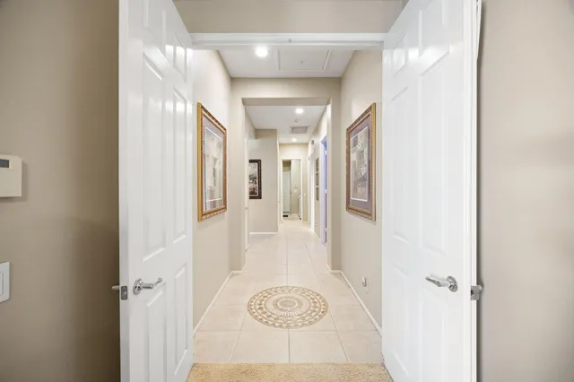 a view of a hallway with wooden floor and a bathroom