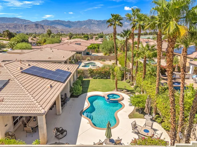 an aerial view of a house with a swimming pool yard and mountain view in back