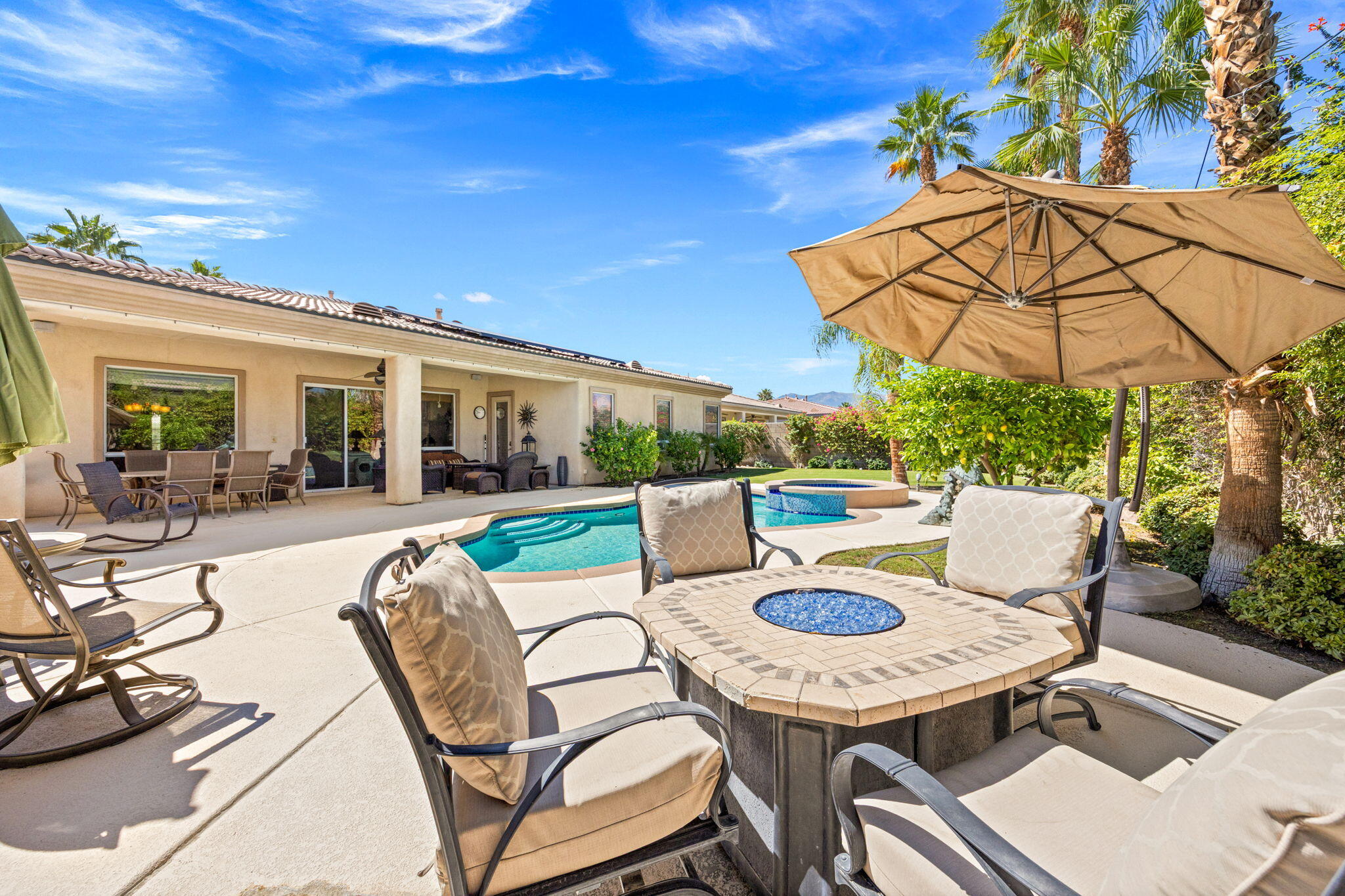 74068 Kokopelli Circle Palm Desert, CA 92211 - Photo 43 of 46 a view of a patio with table and chairs potted plants with wooden floor and fence