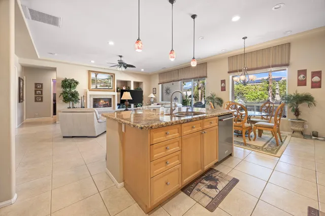 a kitchen with stainless steel appliances granite countertop a sink counter space cabinets and a view of living room