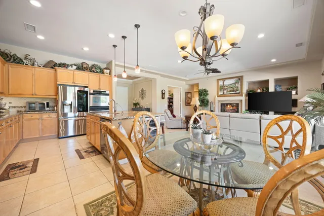 a very nice looking dining room with kitchen island furniture a chandelier stainless steel appliances and kitchen view