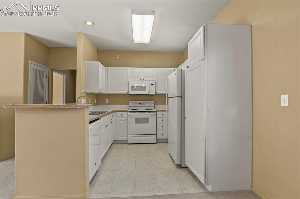 3271 Apogee View Colorado Springs, CO 80906 - Photo 13 of 37 a kitchen with a refrigerator sink and cabinets