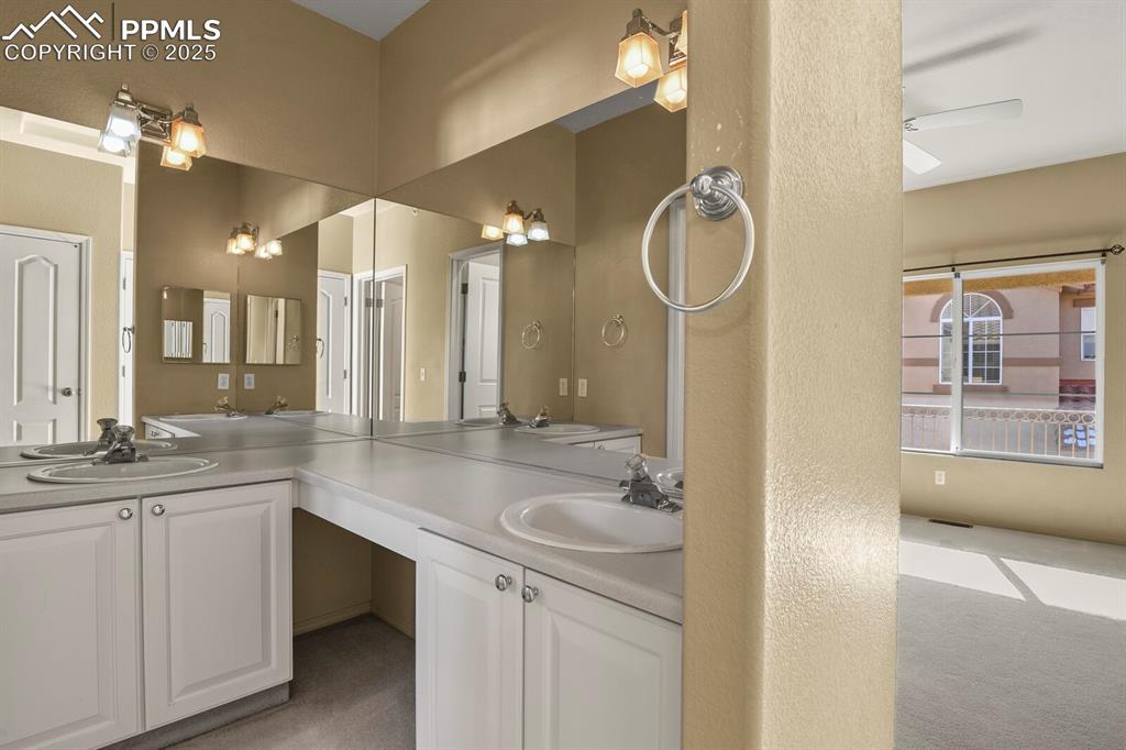 3271 Apogee View Colorado Springs, CO 80906 - Photo 20 of 37 a bathroom with a double vanity sink a mirror and a bathtub