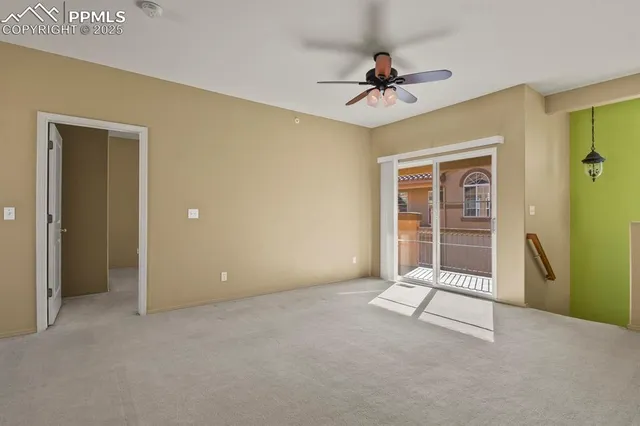a view of an empty room with a ceiling fan