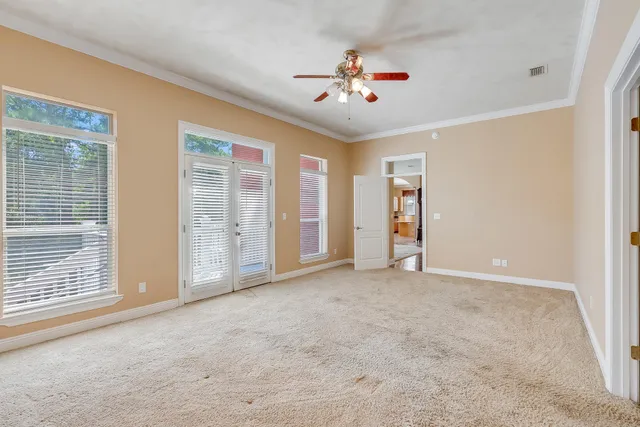 a view of an empty room with a chandelier fan