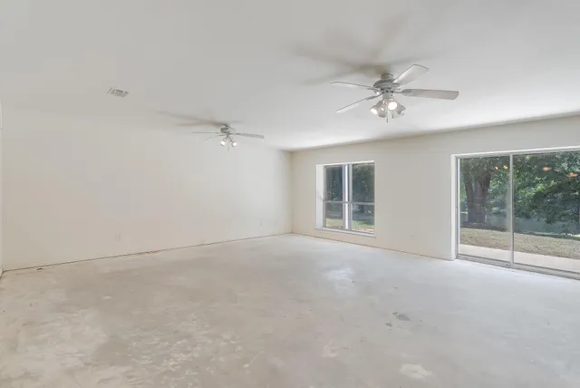 an empty room with a ceiling fan and a bathroom