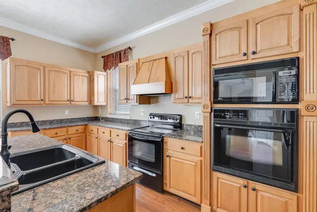 a view of a livingroom with wooden floor and a ceiling fan