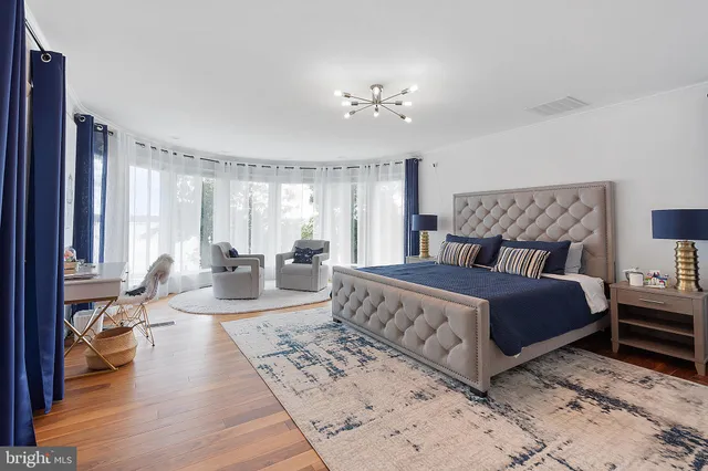 a spacious bedroom with a large bed and a chandelier