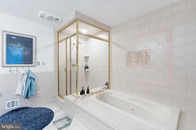 a bathroom with a tub a sink and a mirror