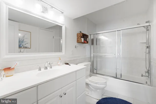 a bathroom with a shower sink vanity mirror and toilet