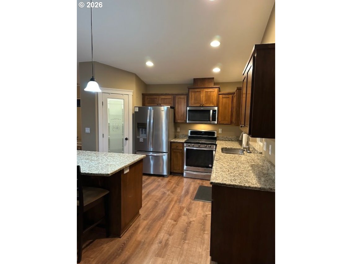 2072 Equestrian Loop South Salem, OR 97302 - Photo 4 of 4 a kitchen with kitchen island granite countertop stainless steel appliances a sink refrigerator and microwave