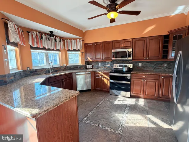 a kitchen with stainless steel appliances granite countertop a sink stove and cabinets