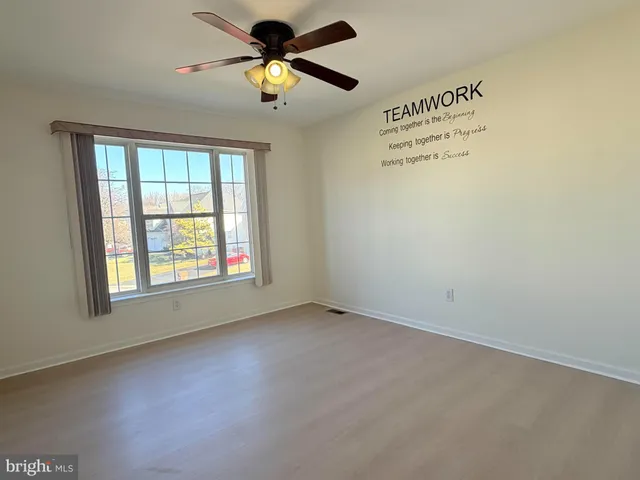 an empty room with a window and a fan