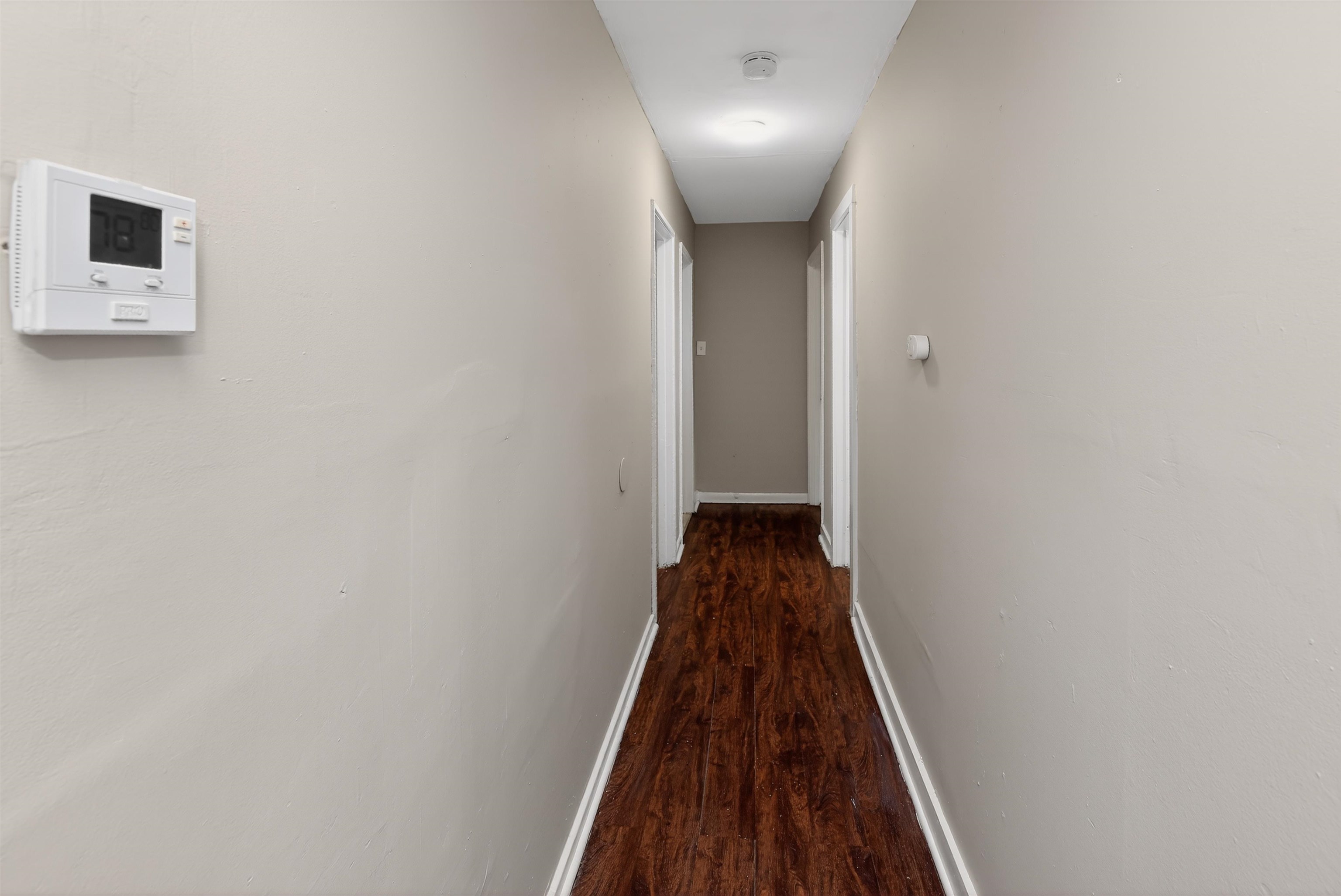 4838 Manson Road Memphis, TN 38109 - Photo 28 of 28 Hallway featuring wood-finish flooring, light neutral wall paint, and white baseboards