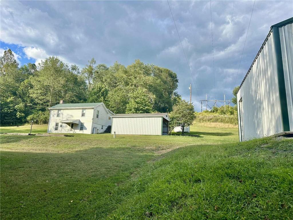 143 Raineytown Road Dawson, PA 15428 - Photo 21 of 42 a view of a big house with a big yard and large trees