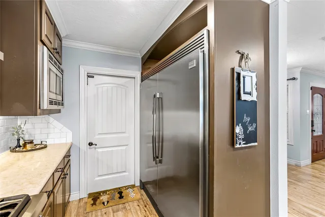 a walk in closet with wooden floor