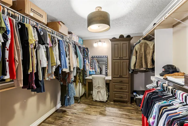 a view of walk in closet with clothes and shoes