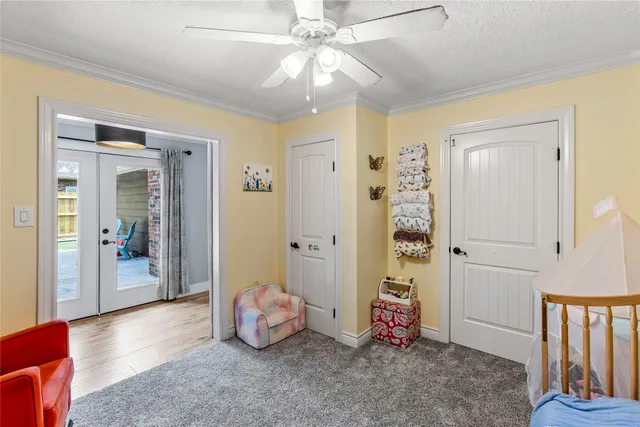 a room with wooden floor and chandelier fan