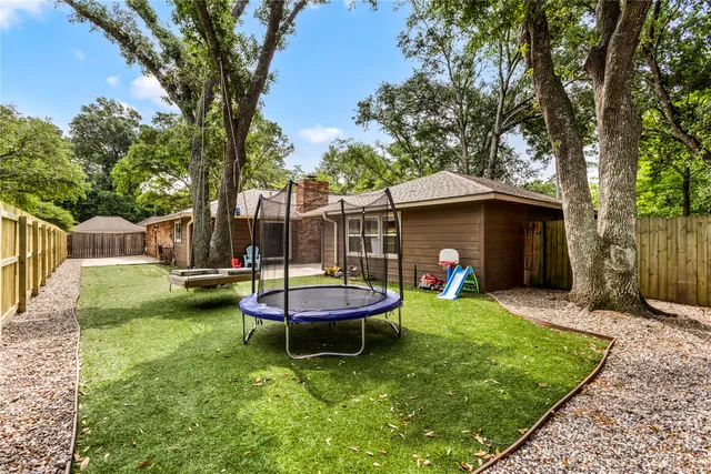 a view of a backyard with table and chairs and a large tree