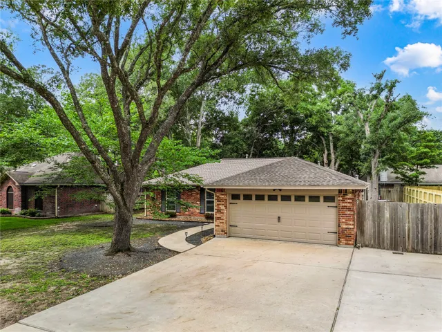 a view of a house with backyard and trees
