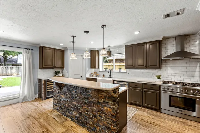 a kitchen with kitchen island granite countertop a sink stove and cabinets