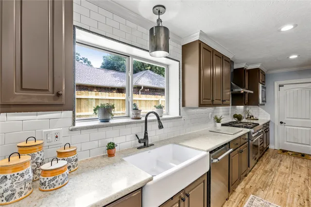 a kitchen with granite countertop a sink stove and cabinets