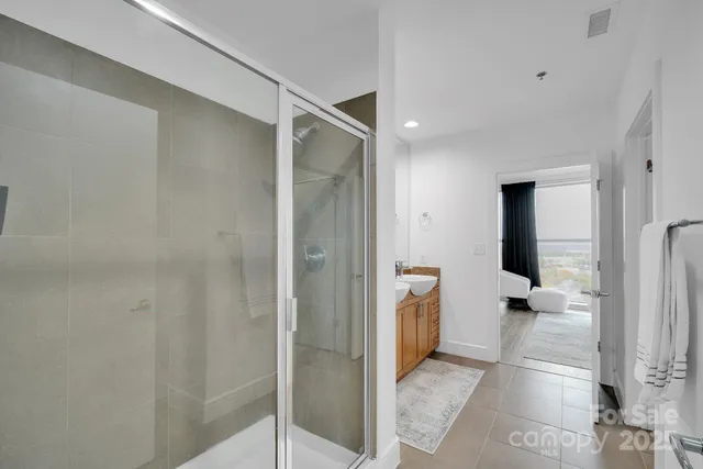 a view of a hallway with toilet and shower