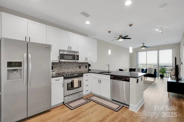 a kitchen with a sink stainless steel appliances and white cabinets
