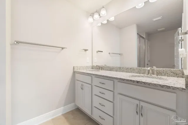 a bathroom with a granite countertop sink a mirror and a shower