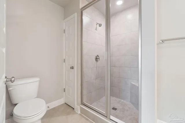 a white toilet next to a bathroom