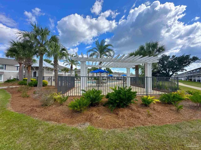 a view of fountain in front of house with a big yard and large trees