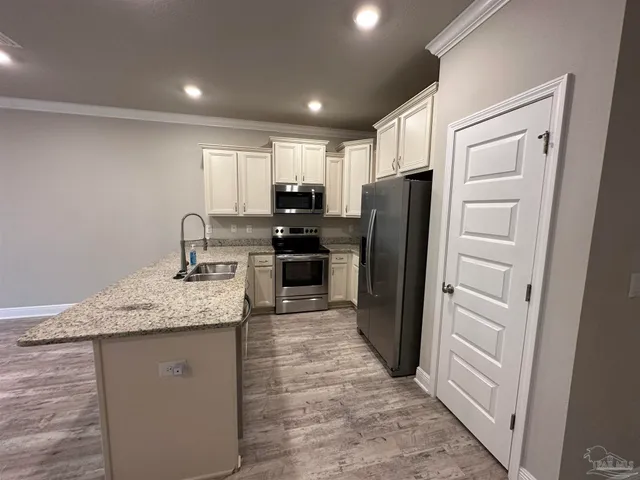 a kitchen with kitchen island granite countertop cabinets and refrigerator